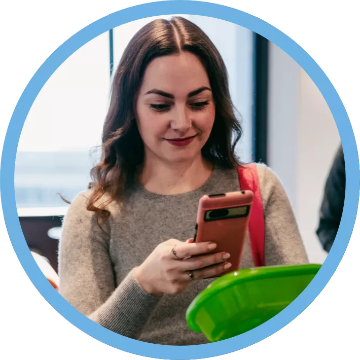 A woman using her phone to scan a reusable container